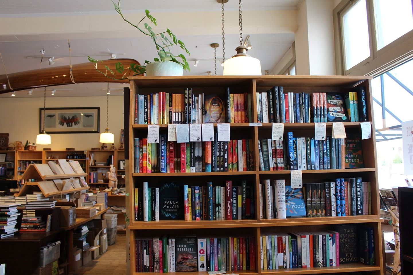 Interior of Birchbark Books featuring shelves of books and canoe on ceiling