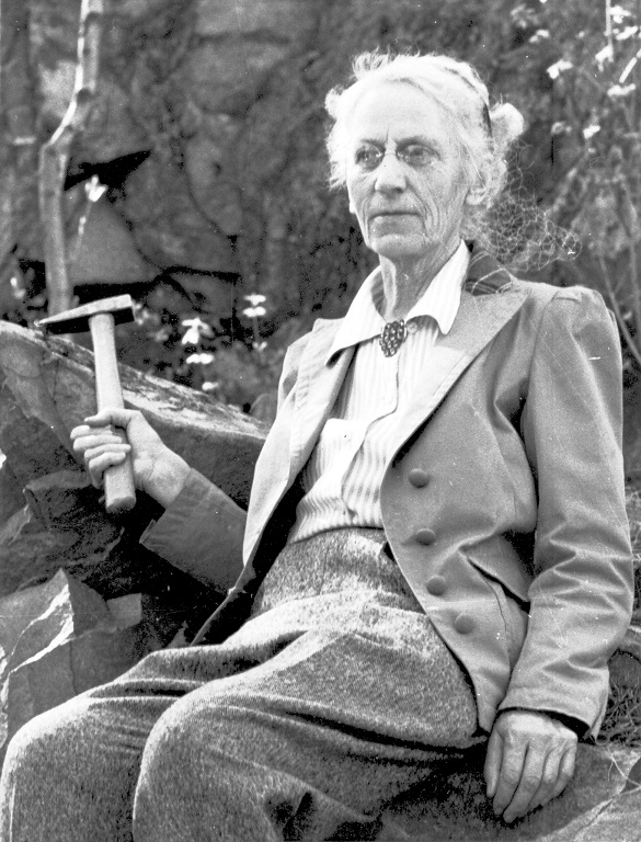 Black and white photo of geologist Alice Wilson holding a chisel