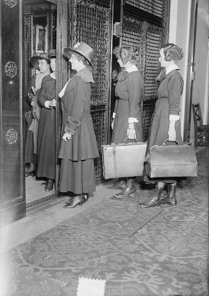 Black-and-white photo of women with suitcases arriving at the Martha Washington Hotel