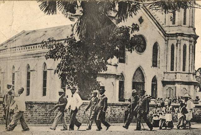 Black-and-white photo of people walking past a Catholic church in Lagos, Nigeria in 1917