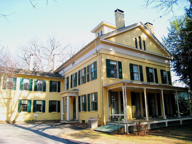 Color photo of Emily Dickinson's home, yellow with green shutters