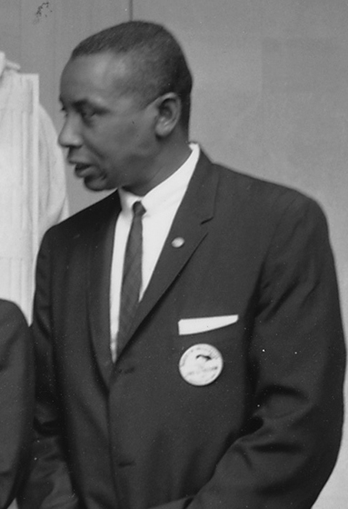 Black-and-white photo of Floyd McKissick, in suit and tie, looking to his right