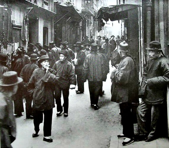 Black and white photo of immigrants milling through San Francisco's Chinatown circa 1900