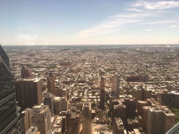 View of South Philadelphia from One Liberty Observation Deck, showing rooftops and streets on grid pattern stretching into the distance on a clear day