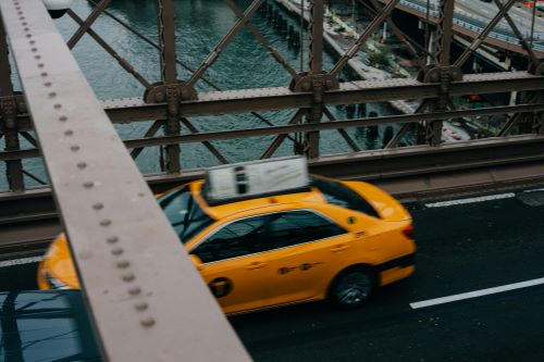 Overhead view of yellow taxi crossing the Brooklyn Bridge