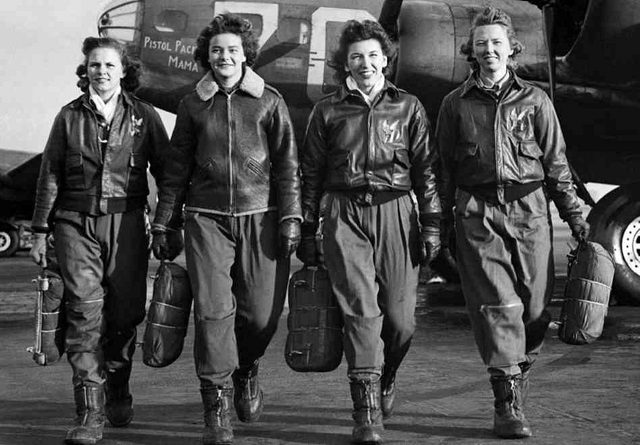 WASP pilots in flight jackets walking in front of military aircraft